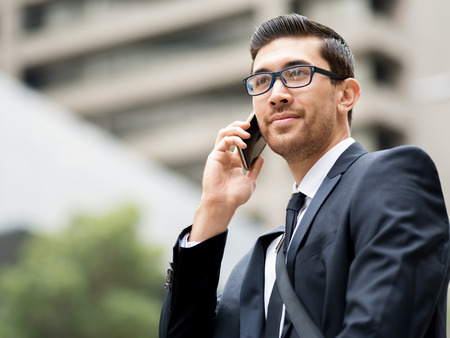 Portrait of young handsome businessman outdoor holding mobile phoneの写真素材