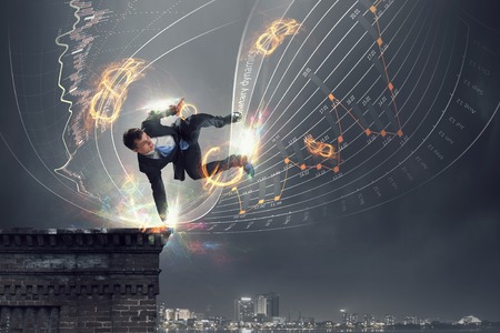 Young cheerful businessman dancing to celebrate his success . Mixed mediaの写真素材