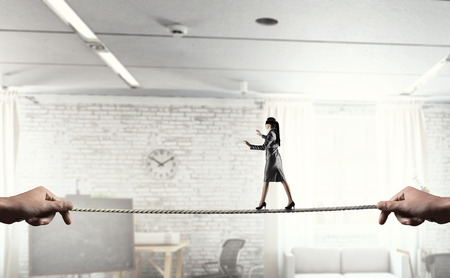 Businesswoman with blindfolder on eyes balancing on the rope. Mixed mediaの写真素材