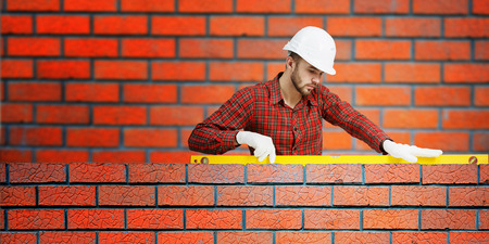 Young handsome man in hardhat with measure levelの写真素材