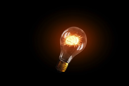 Glass glowing light bulb on dark background