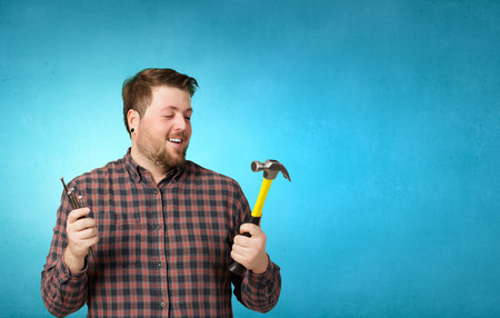 Handyman with hammer and nails in interior