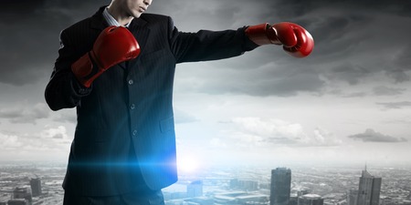 Determined businessman in suit and boxing glovesの写真素材