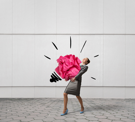 Young businesswoman in interior and crumpled paper as symbol of inspiration. Mixed mediaの写真素材