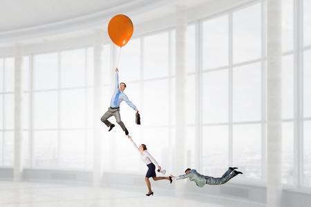 Business people escaping from office on balloon. Mixed mediaの写真素材