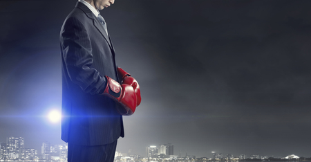 Determined businessman in suit and boxing glovesの写真素材