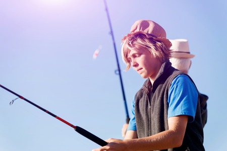 Teenage boy fishing with rod at seaの写真素材