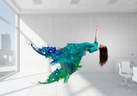Woman in green fashion dress levitating in office. Mixed mediaの写真素材