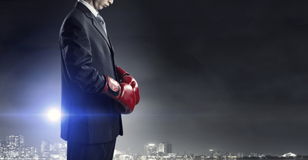 Determined businessman in suit and boxing glovesの写真素材