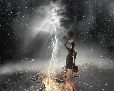 Businesswoman with suitcase and crack in asphalt roadの写真素材