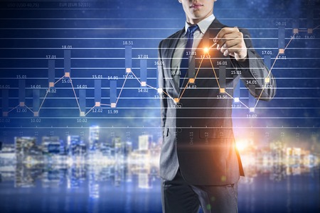 Businessman working on virtual panel with digital infographsの写真素材