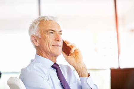 Handsome businessman at the office with mobile phone