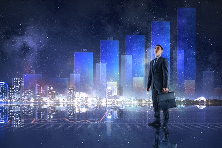 Businessman with suitcase against virtual panel with digital infographsの写真素材