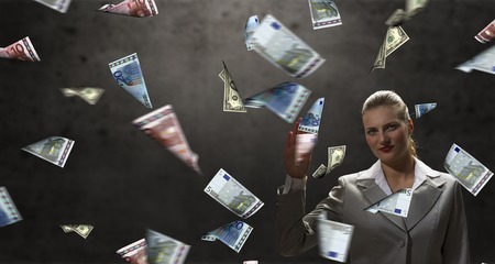Young businesswoman and money banknotes flying in airの写真素材