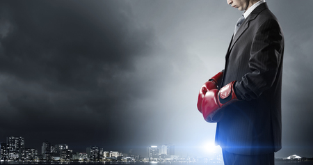 Determined businessman in suit and boxing glovesの写真素材