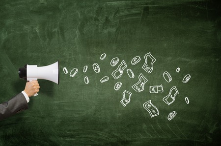 Hand of businessman holding megaphone against chalkboard backgroundの写真素材