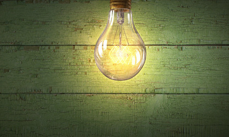 Glass glowing light bulb on wooden backgroundの写真素材