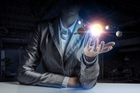 Close of businesswoman holding in palm planet of sun system. Mixed mediaの写真素材