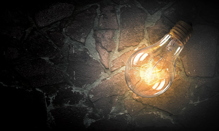 Glowing glass light bulb on concrete backgroundの写真素材
