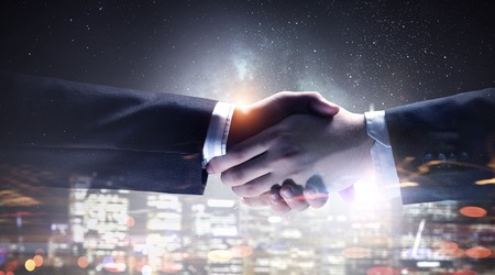 Closeup of business handshake against city backgroundの写真素材