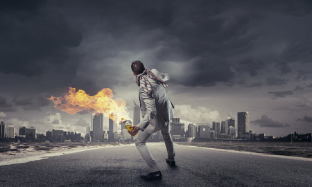 Young aggressive businessman throw burning molotov cocktailの写真素材