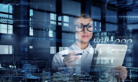 Young woman scientist using tablet pc in her hands. Mixed mediaの写真素材