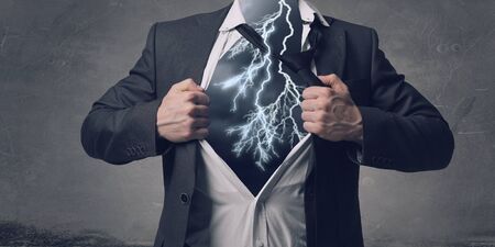 Businessman in classic pose tearing his shirt on chest