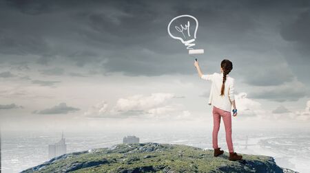 Young pretty woman painting her world with rollerの写真素材