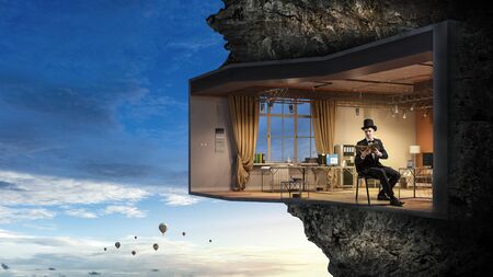 Elegant businessman in interior design build in rock mountain. Mixed mediaの写真素材