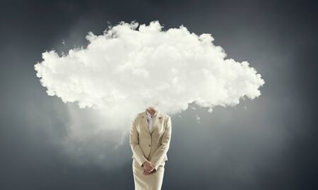 Businesswoman standing with her head in cloudの写真素材