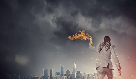 Young aggressive businessman throw burning molotov cocktailの写真素材