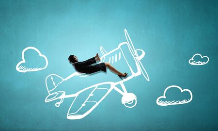 Woman in suit and helmet flying in drawn old styled airplaneの写真素材