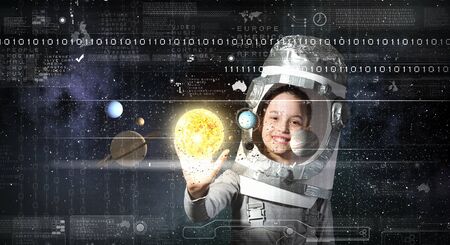 Happy kid girl with carton box on head playing astronaut