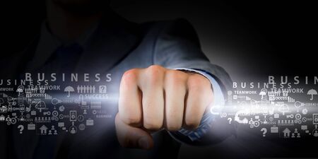 Hand of businessman holding in fist glowing lightの写真素材