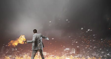 Young aggressive businessman throw burning molotov cocktailの写真素材