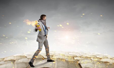 Young aggressive businessman throw burning molotov cocktailの写真素材