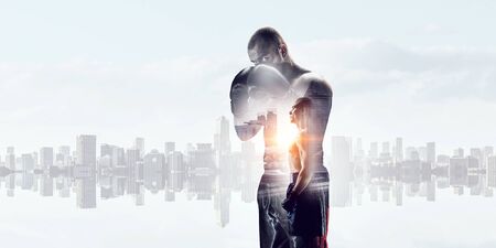 Young box fighter training against cityscape backgroundの写真素材