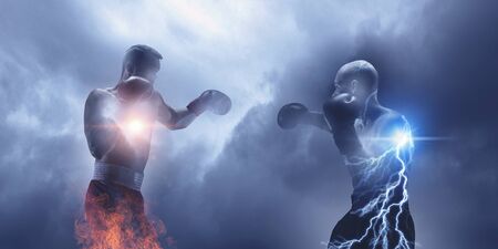 Young box fighter training against sky background