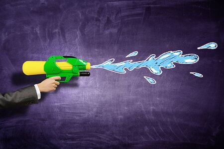 Hand of person holding water gun toyの写真素材