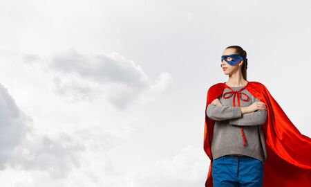 Young attractive woman in mask and red capeの写真素材