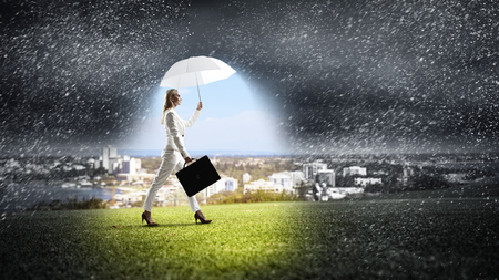 Businesswoman with white umbrella . Mixed mediaの写真素材