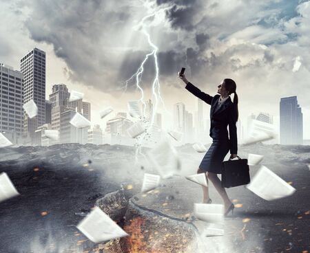 Businesswoman catching moment on her mobile . Mixed mediaの写真素材