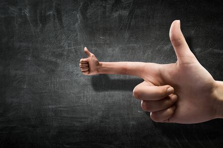 Closeup of male hand and thumb up on forefingerの写真素材