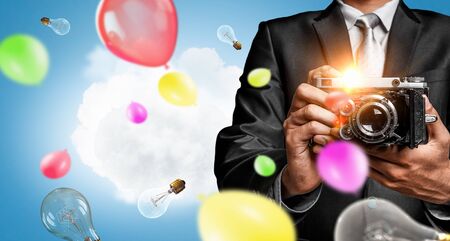 Businessman taking photo with vintage cameraの写真素材