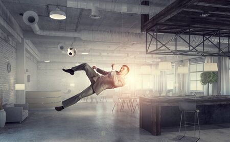 Playing football in office . Mixed mediaの写真素材