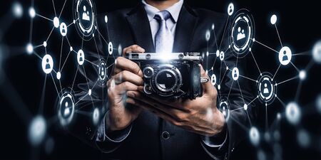 Businessman taking photo with vintage camera . Mixed media