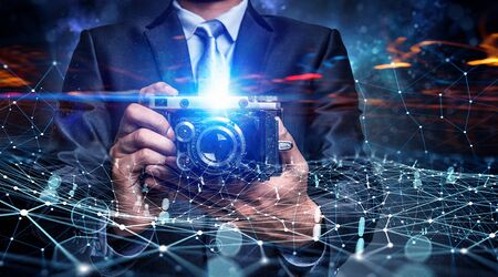 Businessman taking photo with vintage camera . Mixed media