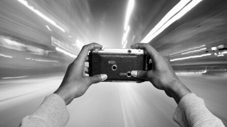 Businessman taking photo with vintage camera . Mixed media