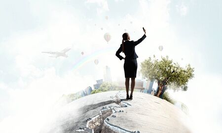 Businesswoman catching moment on her mobile . Mixed mediaの写真素材