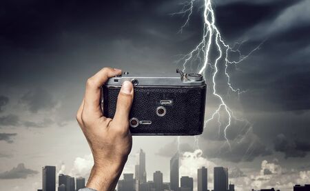 Man taking photo with vintage camera . Mixed media